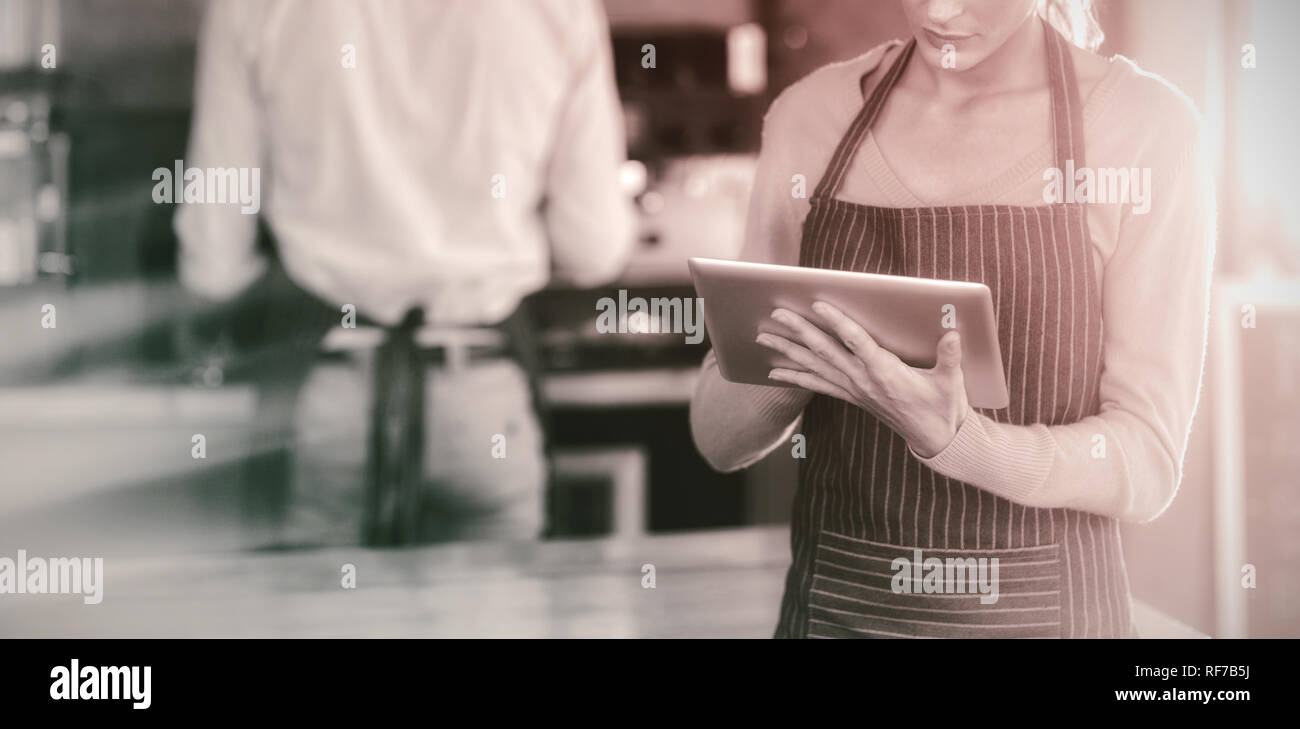 Waitress using digital tablet at counter Stock Photo