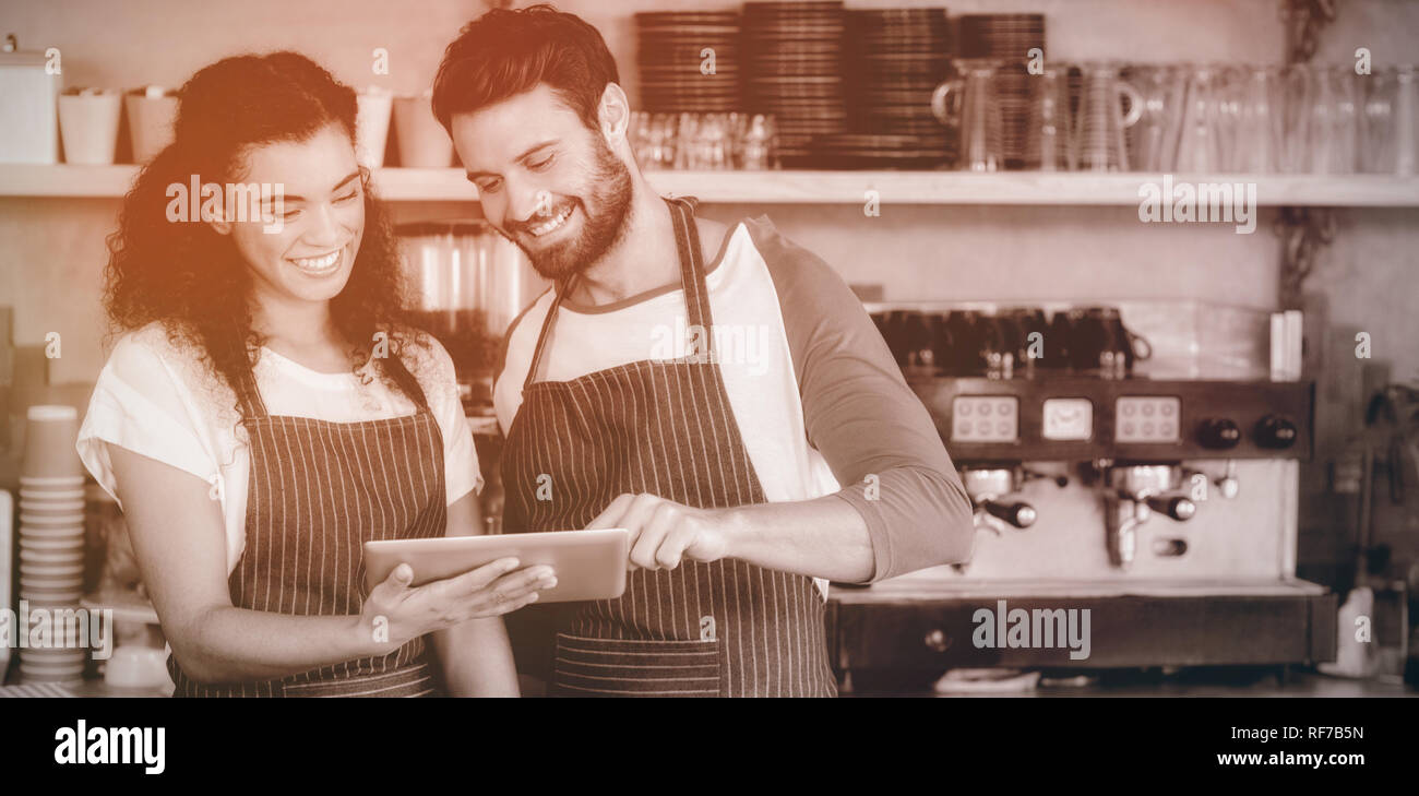 Smiling waiter and waitress using digital tablet at counter Stock Photo