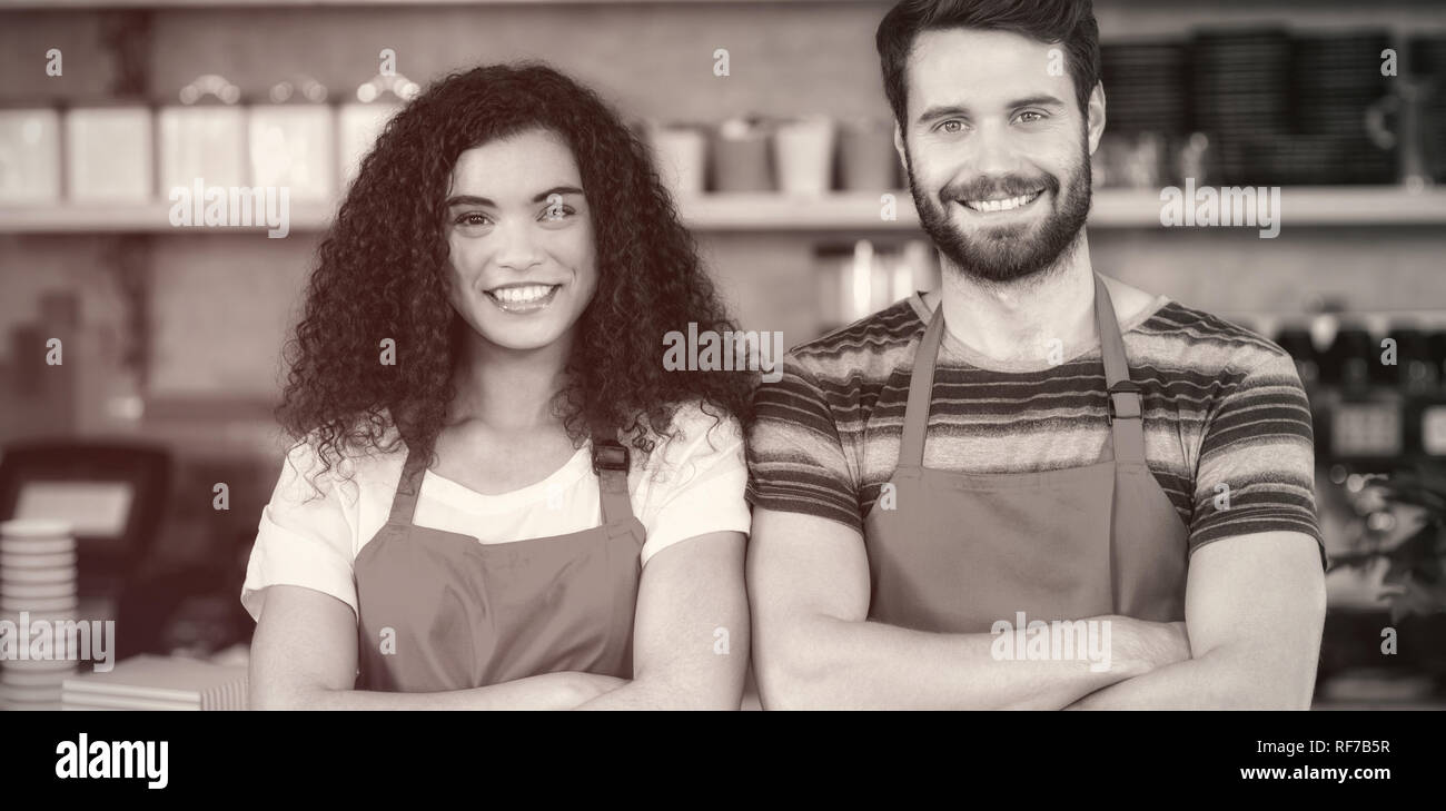 Portrait of smiling waiter and waitress standing at counter Stock Photo