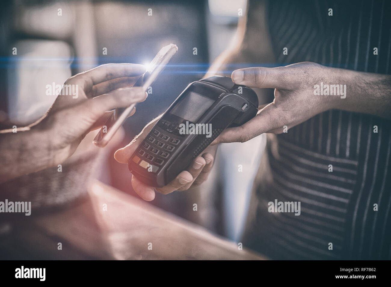Woman paying bill through smartphone using NFC technology Stock Photo
