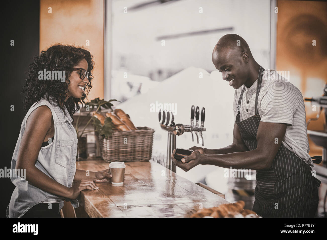 Woman making payment through credit card at counter Stock Photo - Alamy