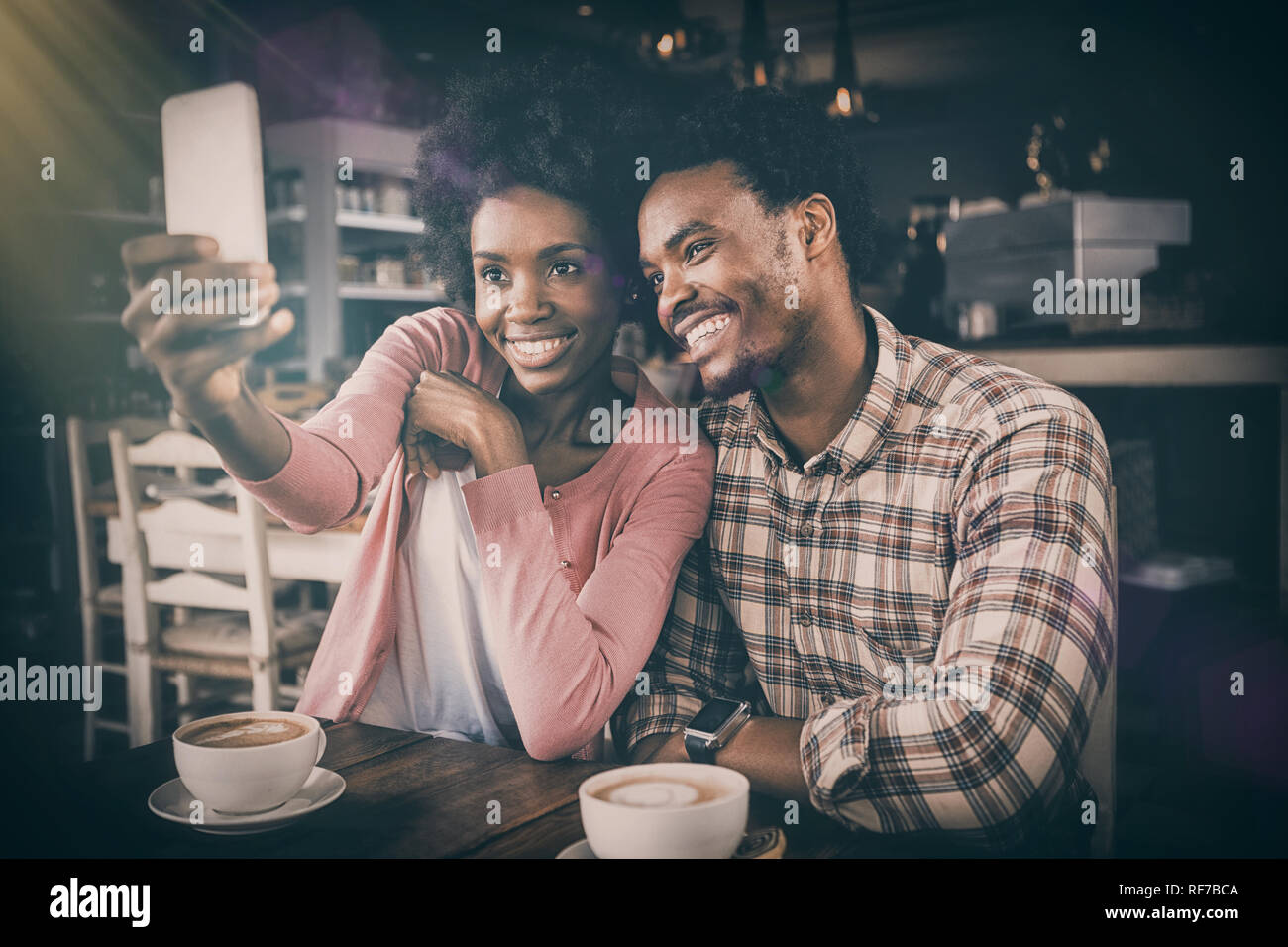 Happy young couple taking selfie in cafeteria Stock Photo
