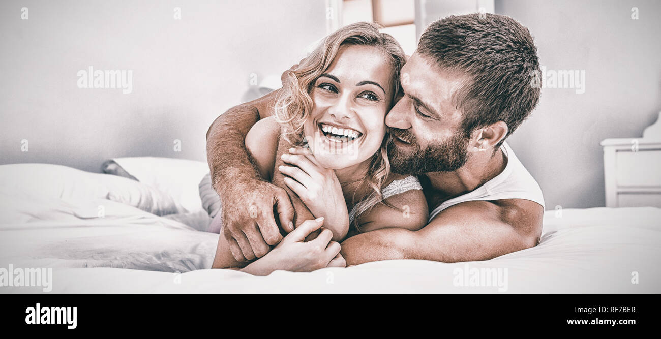 Young couple embracing on bed Stock Photo