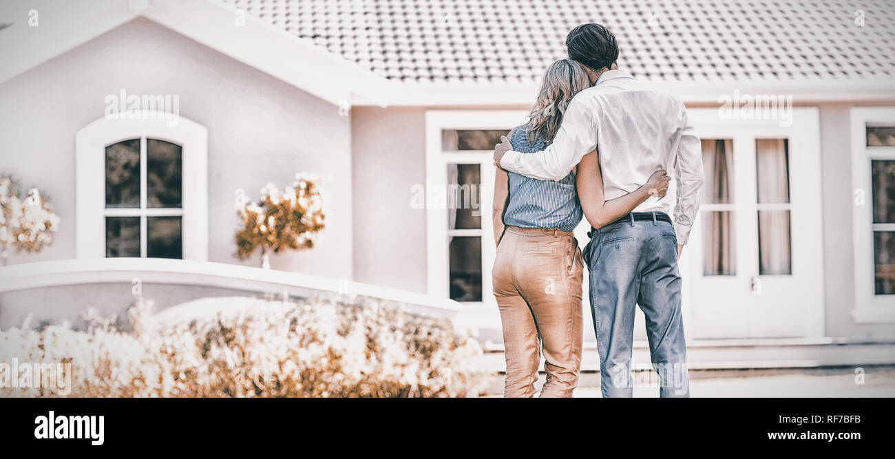 Rear view of couple standing with arm around Stock Photo