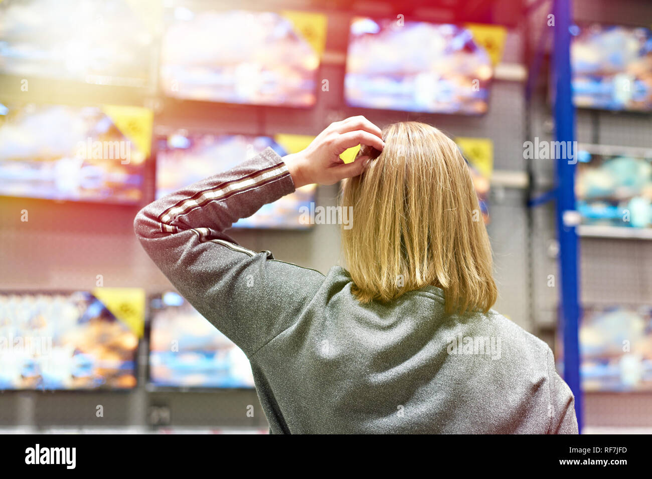 Buyer woman selects TV in store Stock Photo
