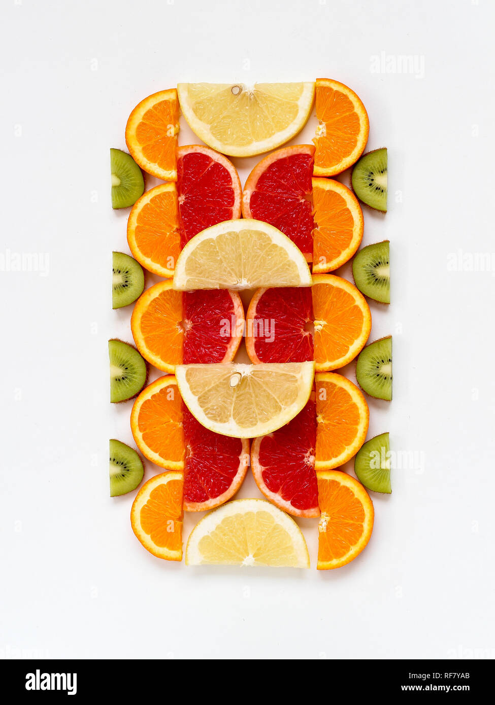 Creative pattern of sliced fruits - kiwi, orange and grapefruits, flat lay style Stock Photo
