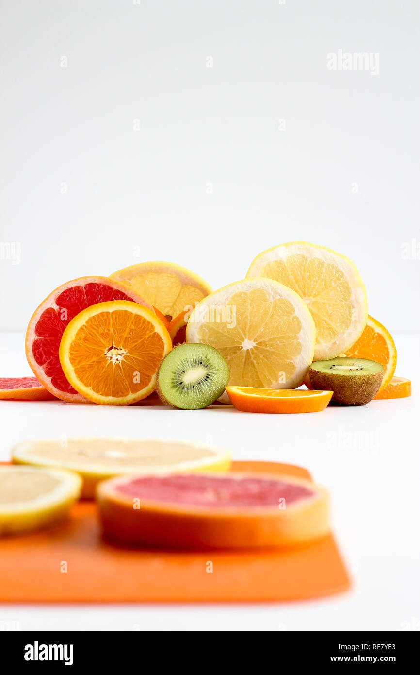 Layers of sliced fruits - kiwi, orange and grapefruits, with first plan Stock Photo