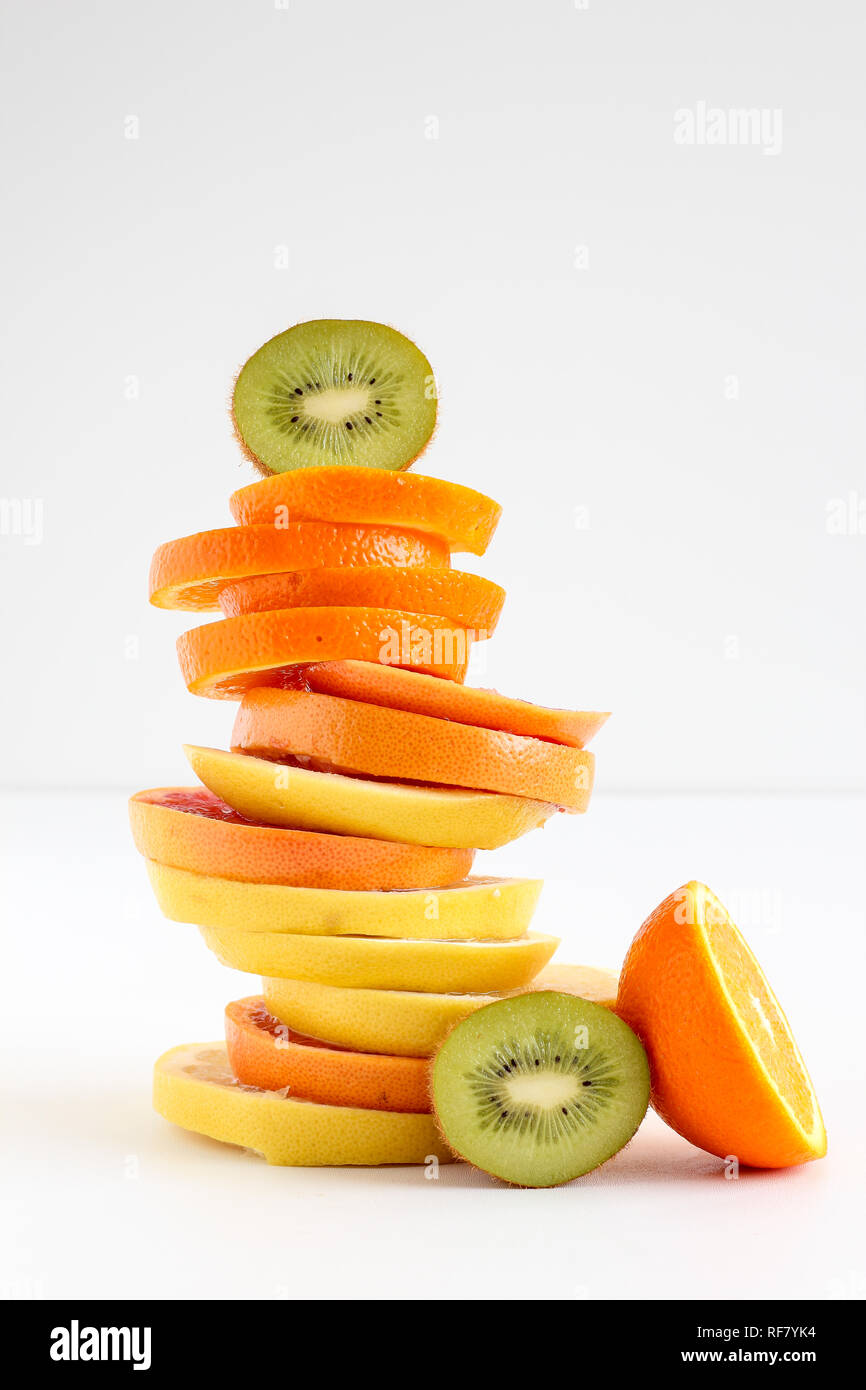 Stacked sliced fruits - kiwi, orange and grapefruits Stock Photo