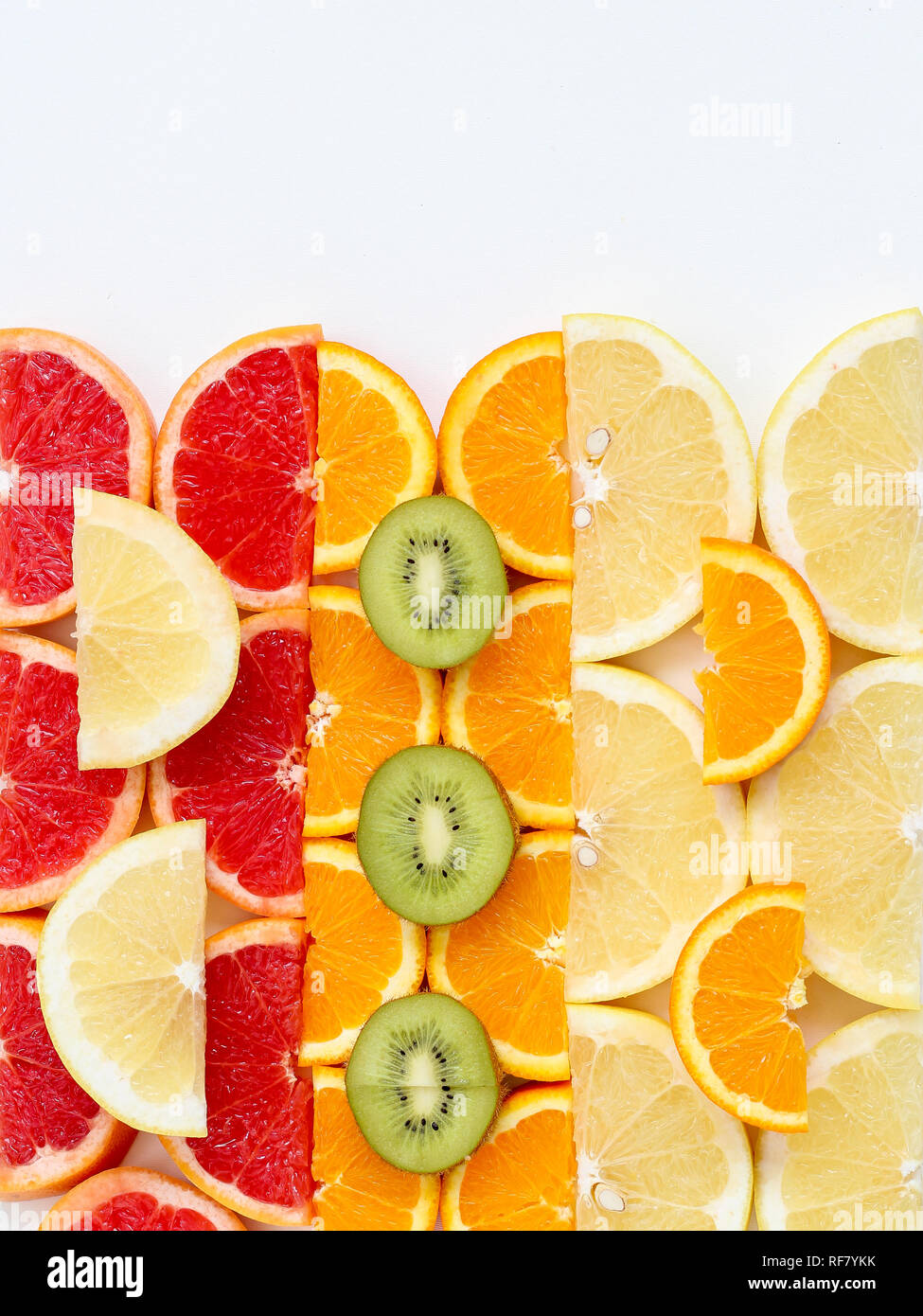 Creative pattern of sliced fruits - kiwi, orange and grapefruits, flat lay style with a copy space on top Stock Photo