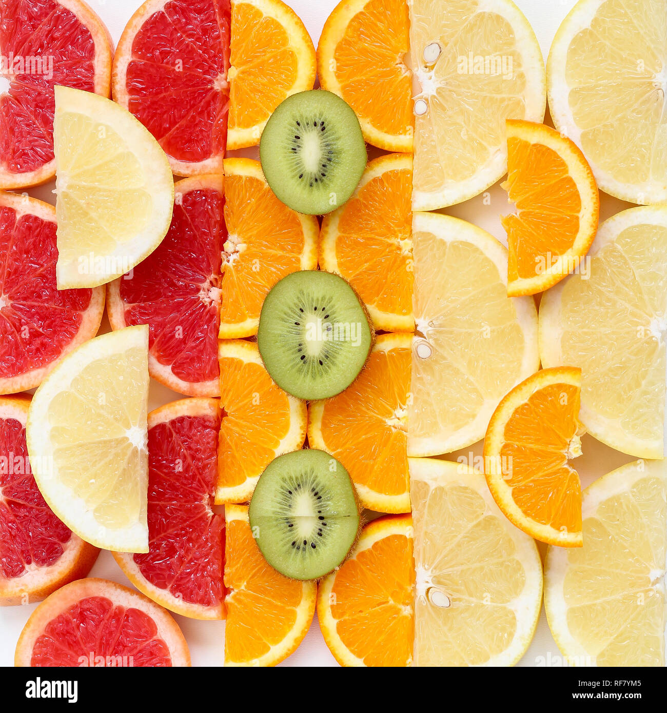 Creative pattern of sliced fruits - kiwi, orange and grapefruits, close up Stock Photo