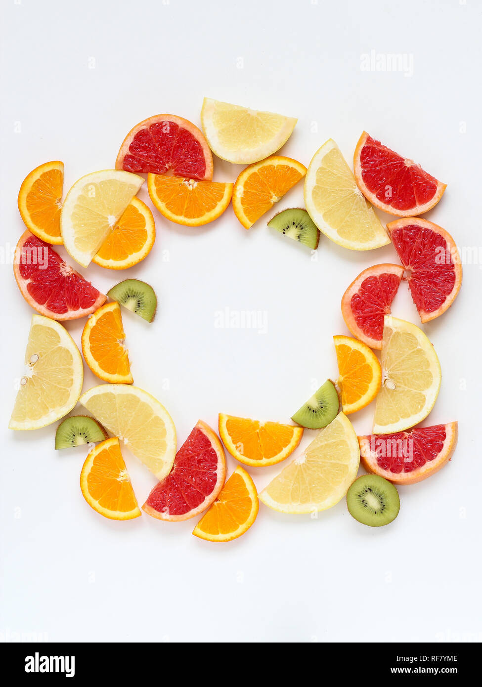 Creative circle arrangement of sliced fruits - kiwi, orange and grapefruits. Flat lay with copy space Stock Photo