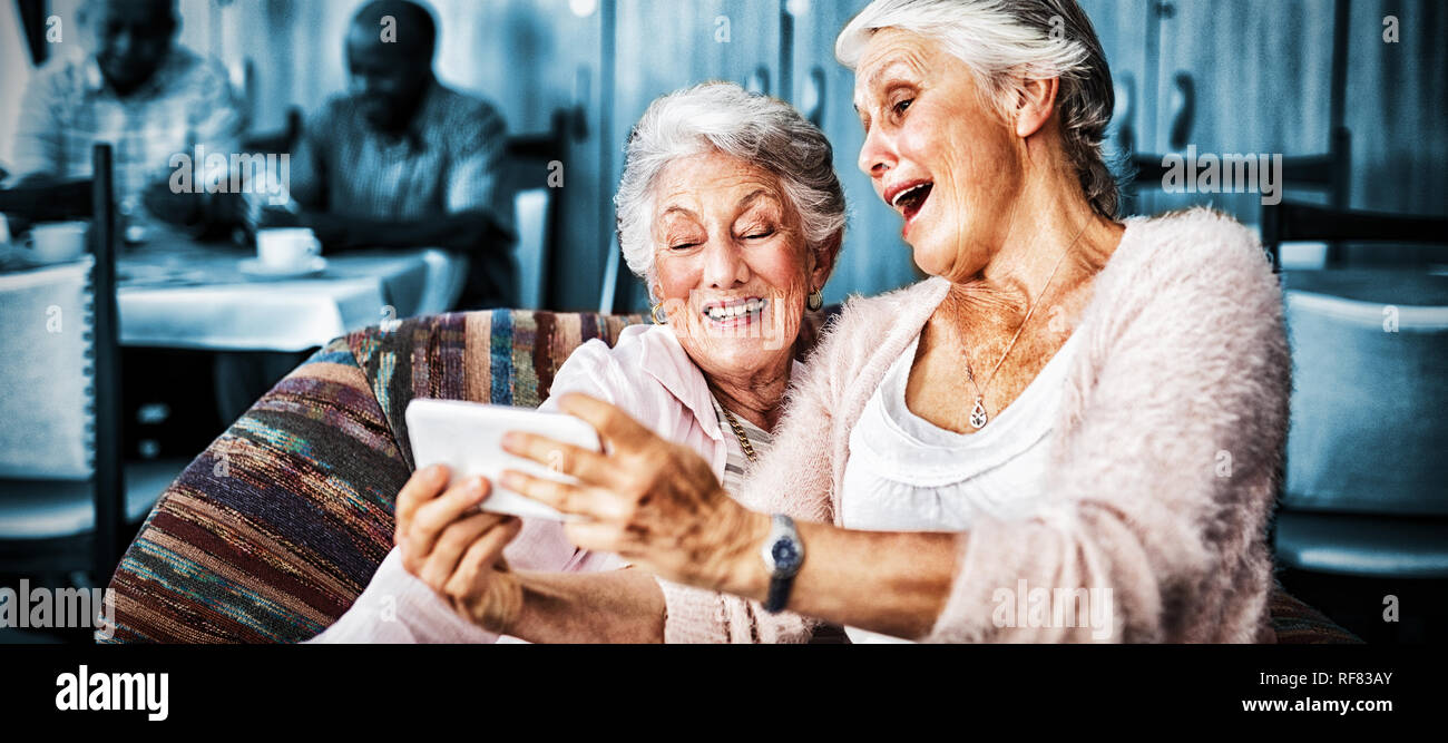Senior friends taking selfie through smart phone Stock Photo