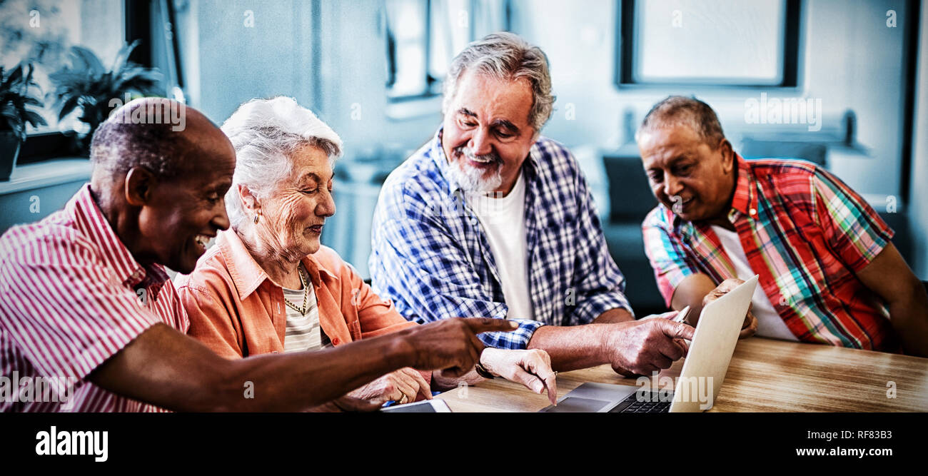 Happy senior men and woman using laptop Stock Photo