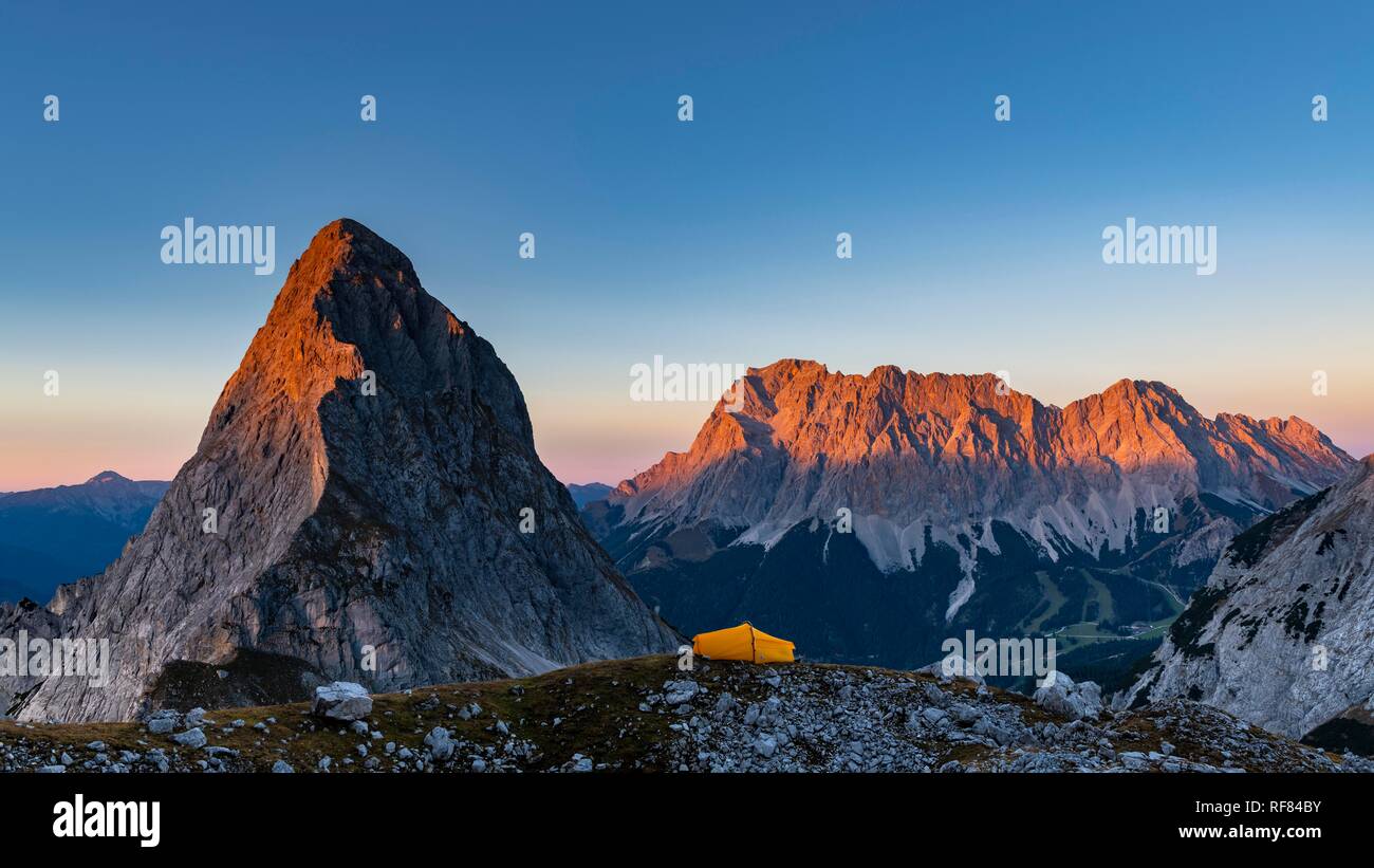 Summit of the Sonnenspitze and tent with Zugspitze in the background at evening light, Ehrwald, Außerfern, Tyrol, Austria Stock Photo