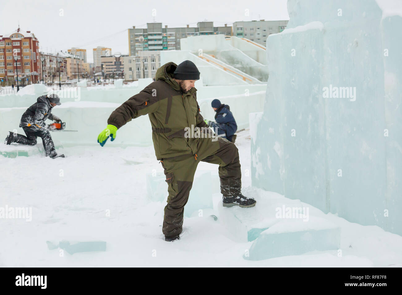 Portrait of a worker at an assembly site of an ice town in winter overalls Stock Photo