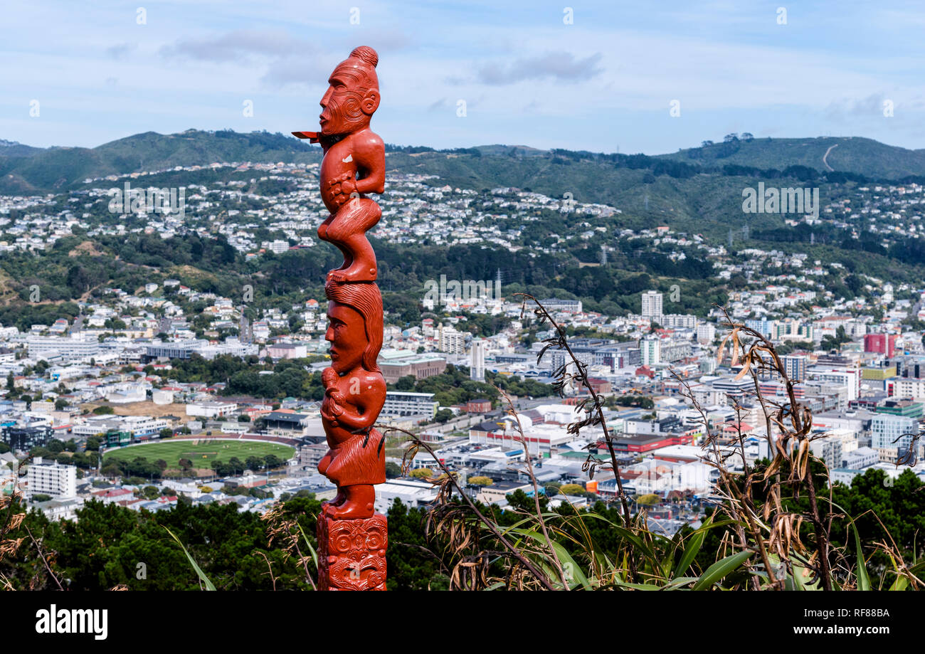 A red pou whenua or land post watches over the skyline of New Zealand's capital city Wellington from Mt Victoria lookout, on a warm autumn day. Stock Photo