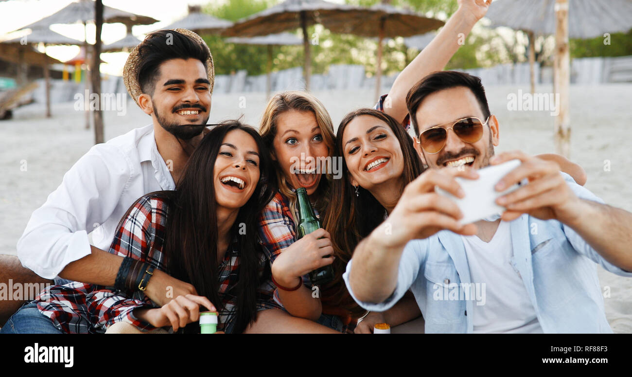 Happy group of young people having fun on beach Stock Photo - Alamy
