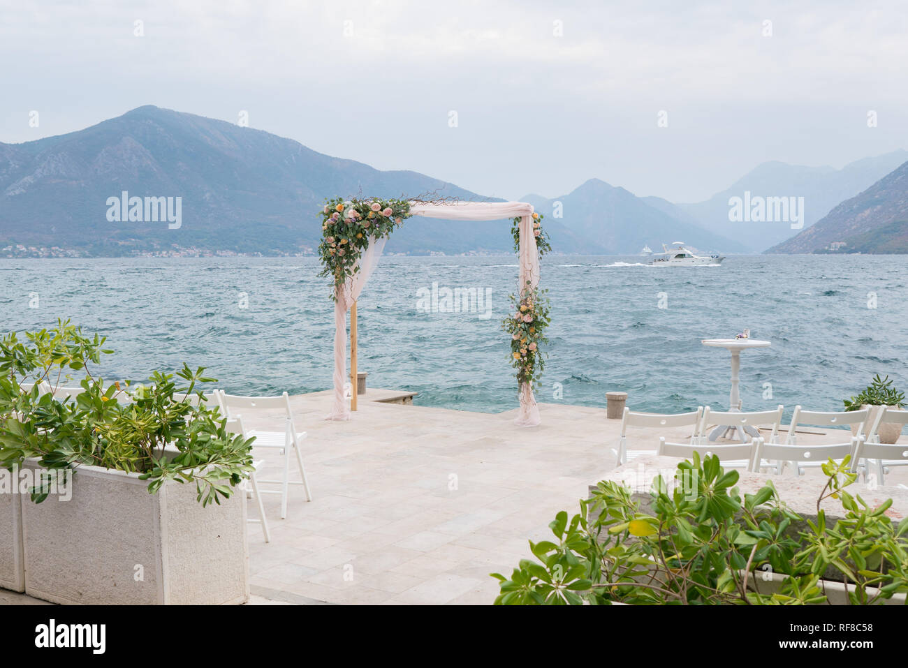 Wooden Rectangular Wedding Arch Decorated With Flowers Against The
