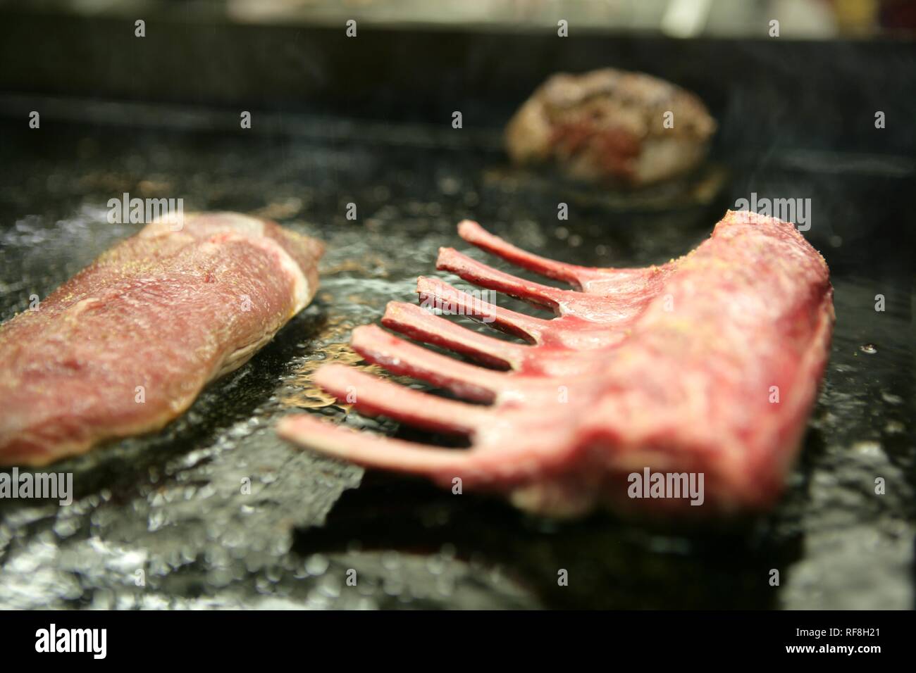 Grilling a rack of lamb at a restaurant kitchen Stock Photo - Alamy