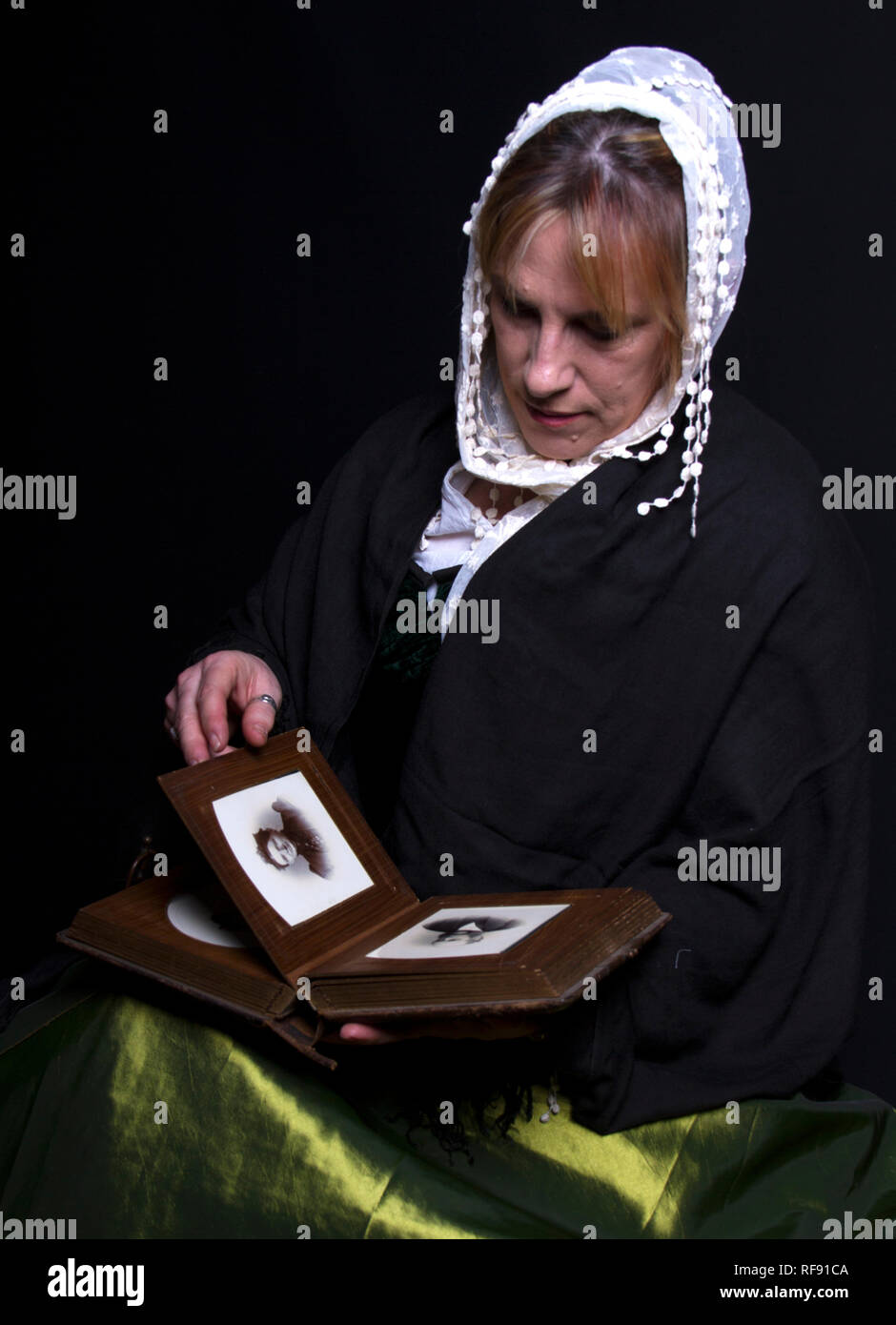 Dickensian costumed  lady reading antique book Stock Photo