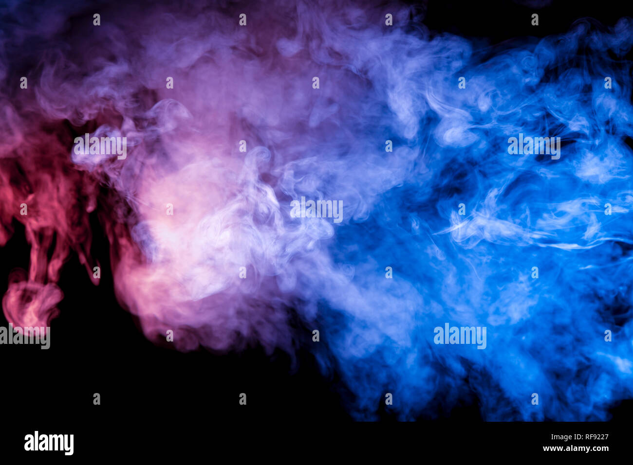A colorful neon smoke pattern on a dark background with a transition from  blue to violet in color, with white particles of star dust Stock Photo