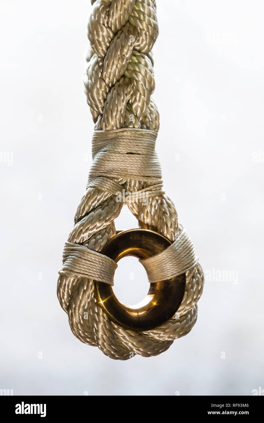 Rope with splice and bronze round thimble (low friction ring) on white background. Stock Photo