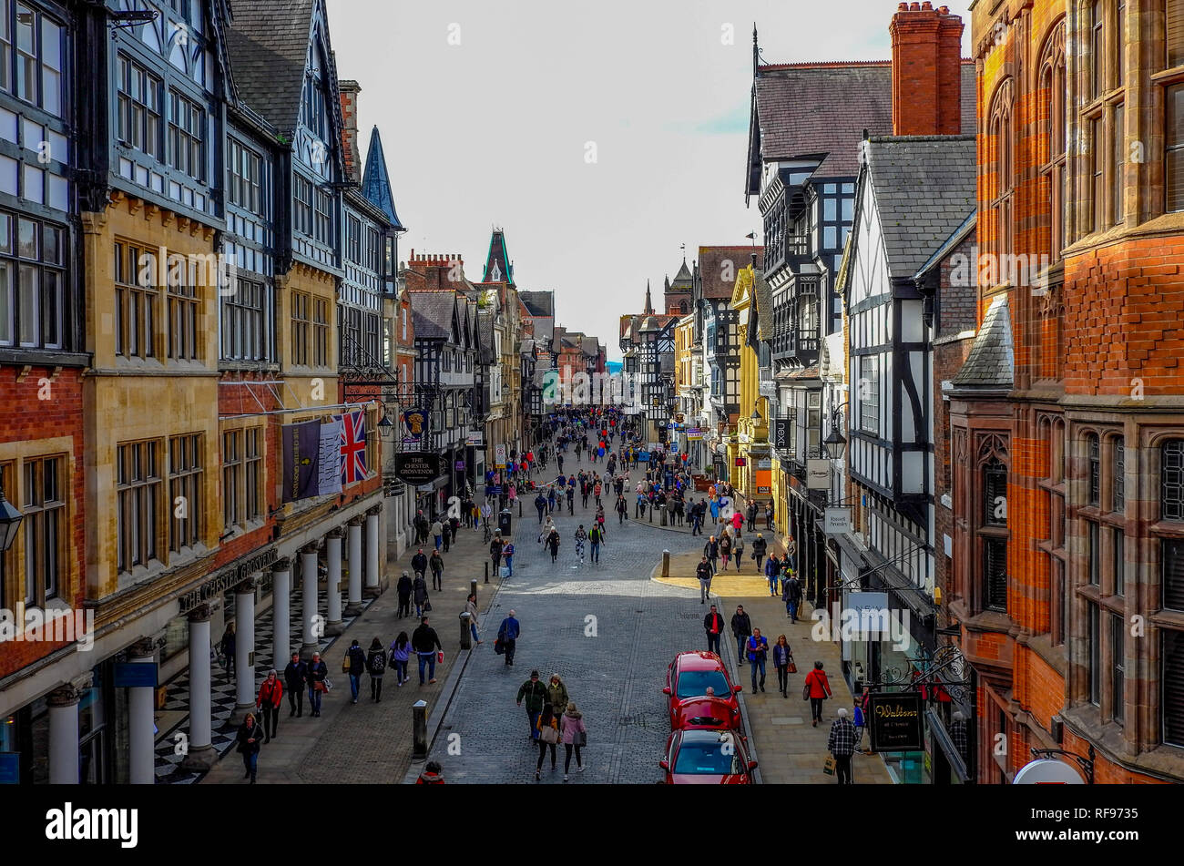 Oct 6, 2018 - Chestster UK:  Historic buildings on a narrow street with crowds of touritst shopping in this old and popular city. Stock Photo