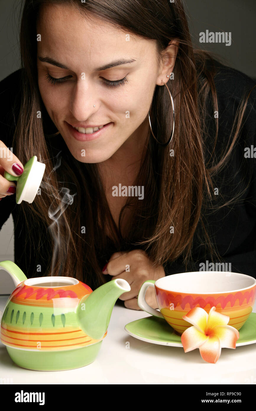 Woman pouring herself a cup of hot tea Stock Photo