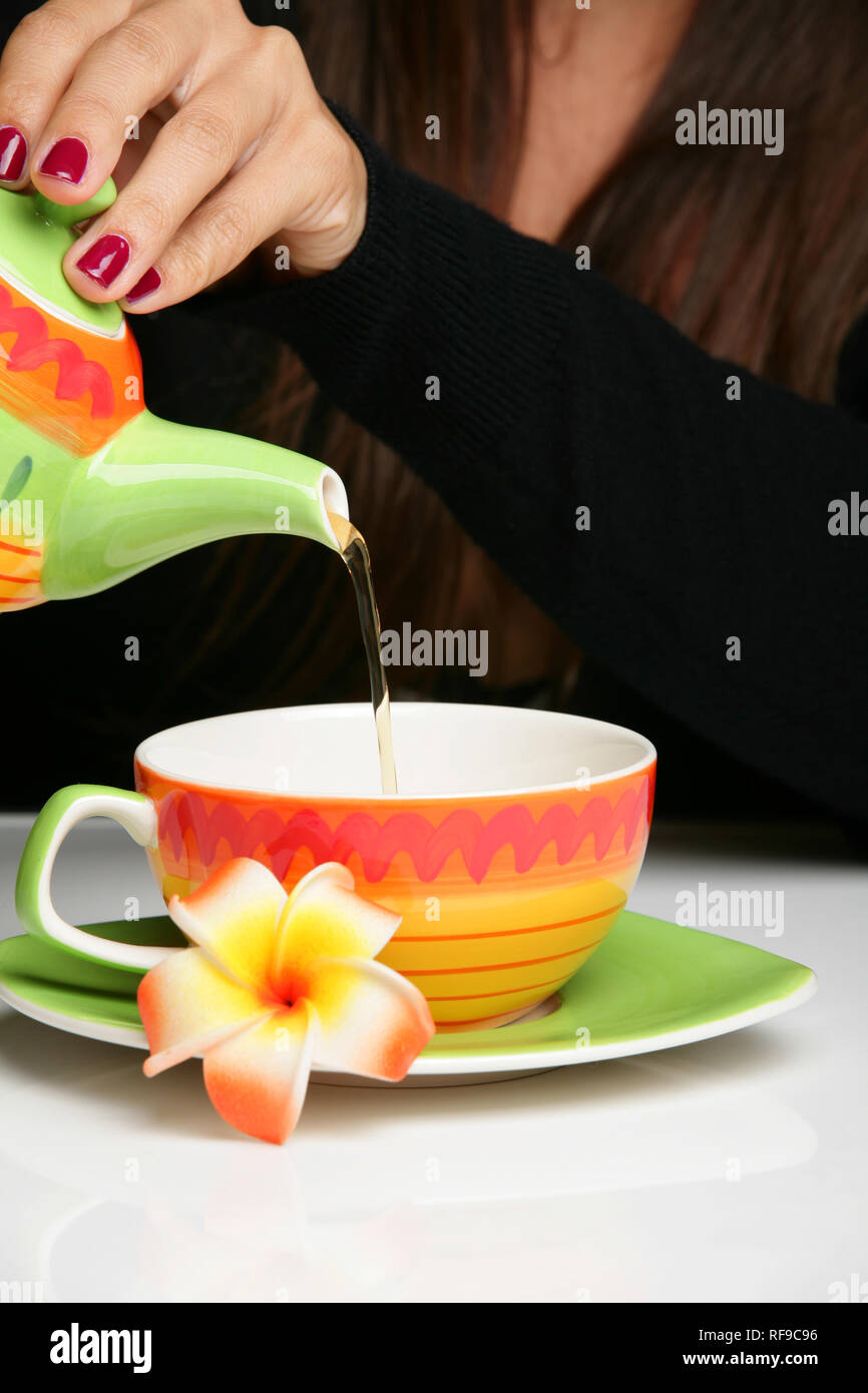 Woman pouring herself a cup of hot tea Stock Photo