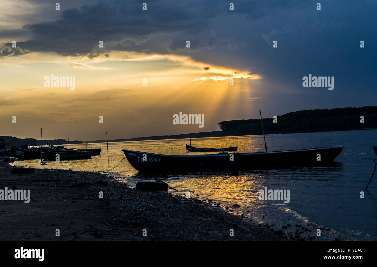 Beautiful sun beams over a river and fishing boats Stock Photo