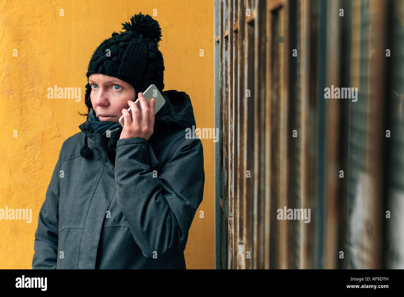 Resentful woman portrait during mobile phone conversation call on the street in winter Stock Photo