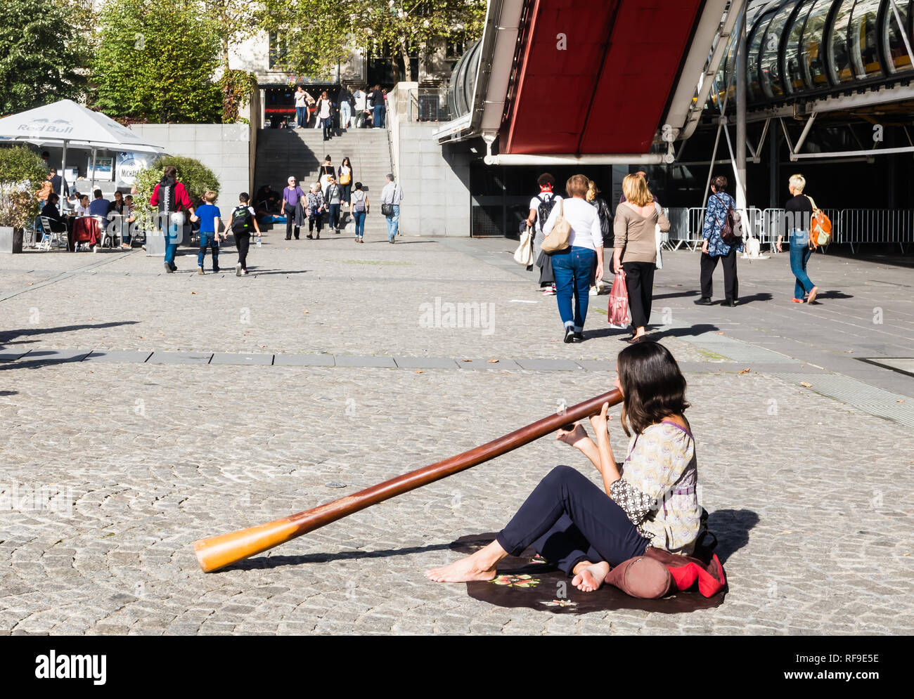 Female street performer, playing the didgeridoo (didjeridu) in paris on place pompidou in france Stock Photo