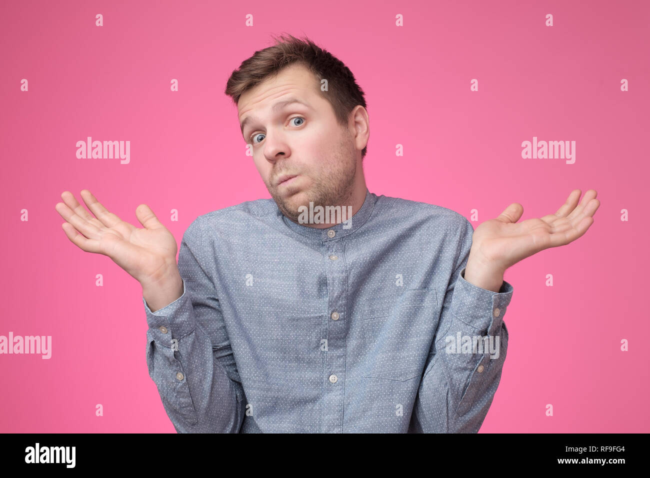 So what, Who cares. Unsure doubtful man shrugging his shoulders in questioning gesture Stock Photo