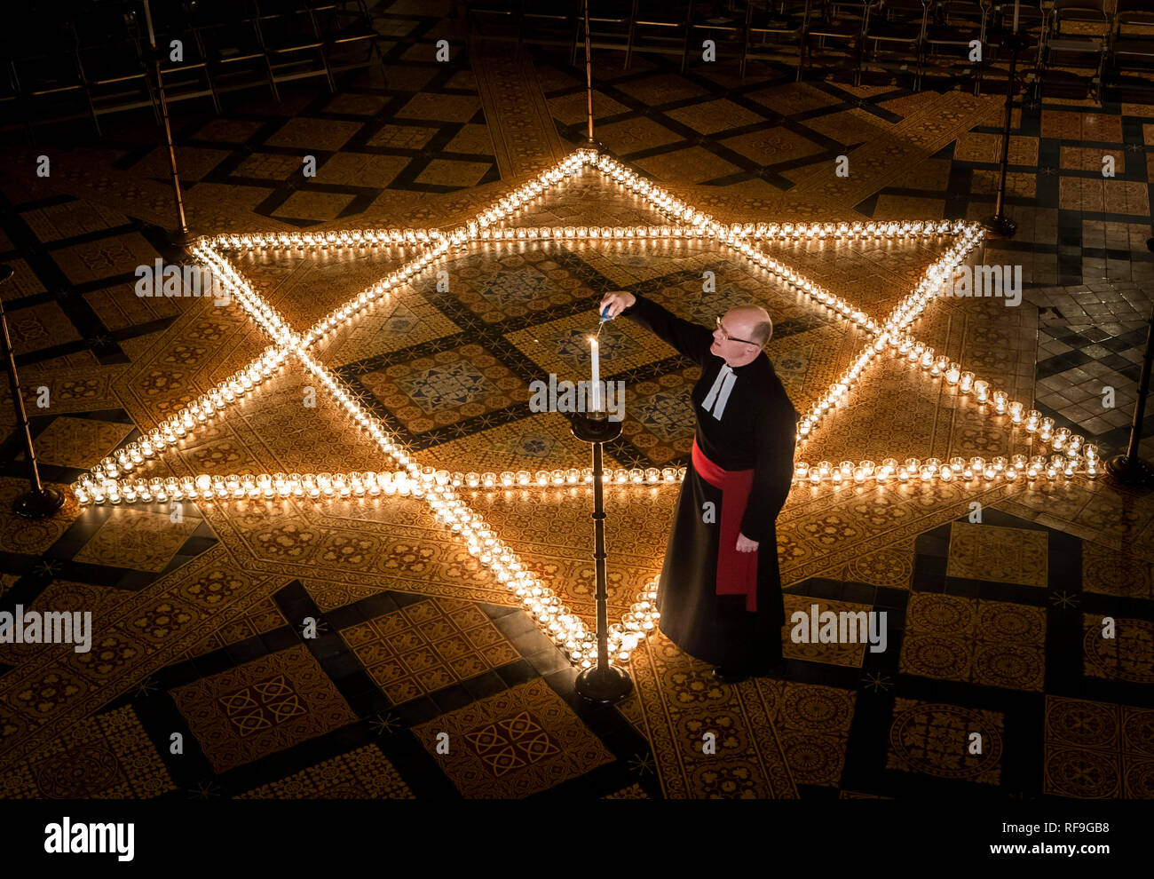 Canon Chancellor Christopher Collingwood helps light six hundred candles in the shape of the Star of David, in memory of more than 6 million Jewish people murdered by the Nazis in the Second World War, at York Minster in York. Stock Photo