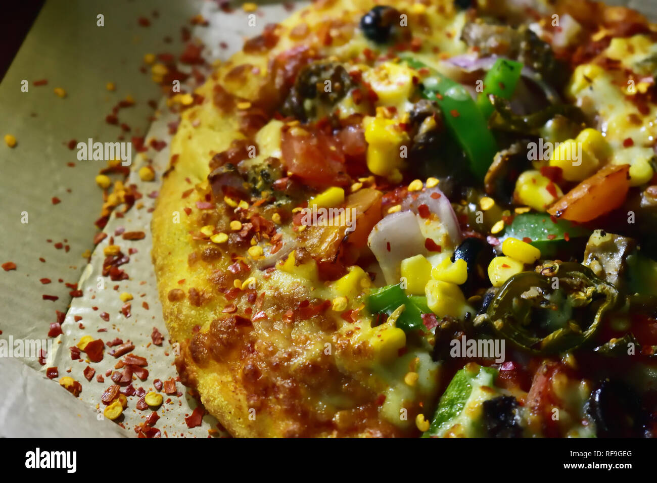 Tasty Veg Pizza topped with Black olives , capsicum,onion,grilled mushroom,corn,tomato,jalapeno and extra cheese Stock Photo