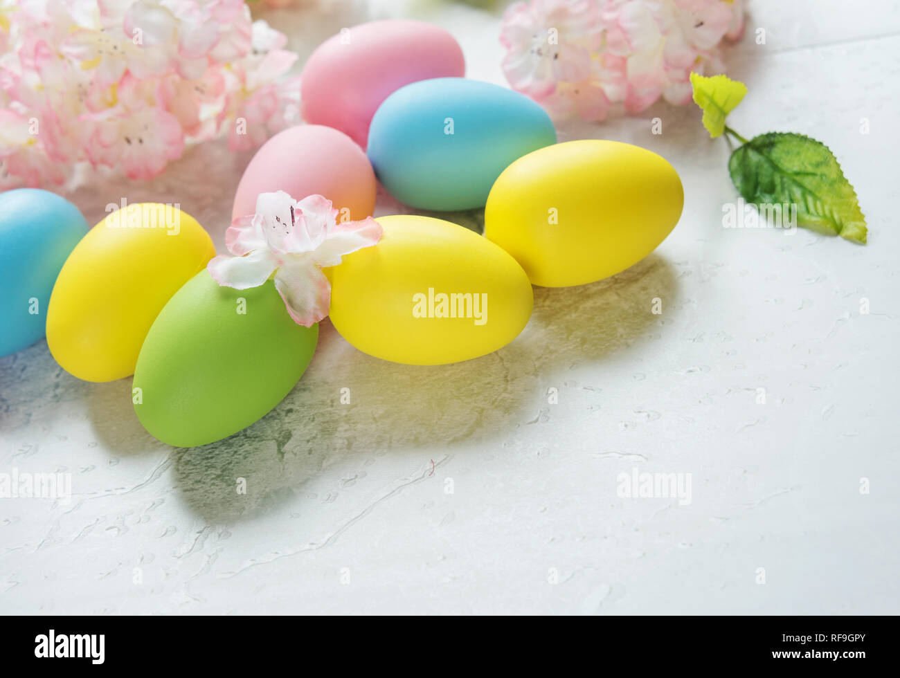 Beautiful delicate Easter composition with pink cherry flowers and multicolored Easter eggs Stock Photo
