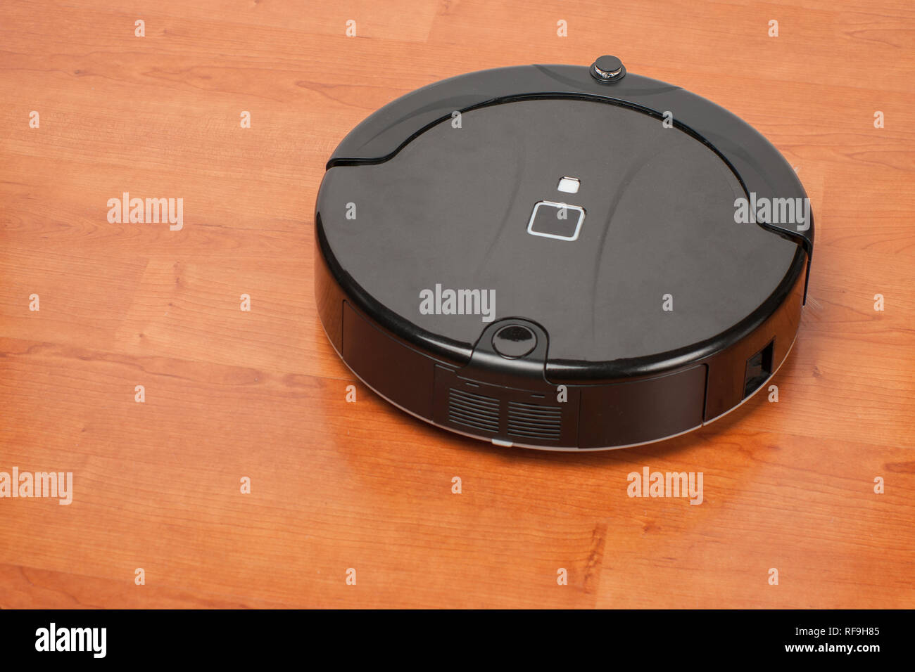 robotic vacuum cleaner working on laminate wood floor. smart cleaning