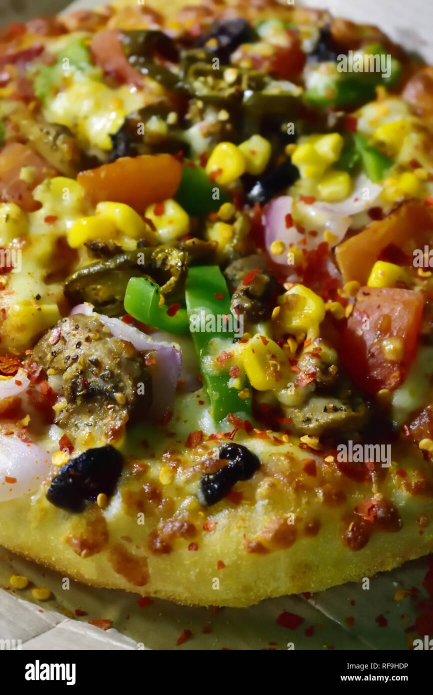 Whole Veg Pizza topped with Black olives , capsicum,onion,grilled mushroom,corn,tomato,jalapeno,extra cheese Stock Photo