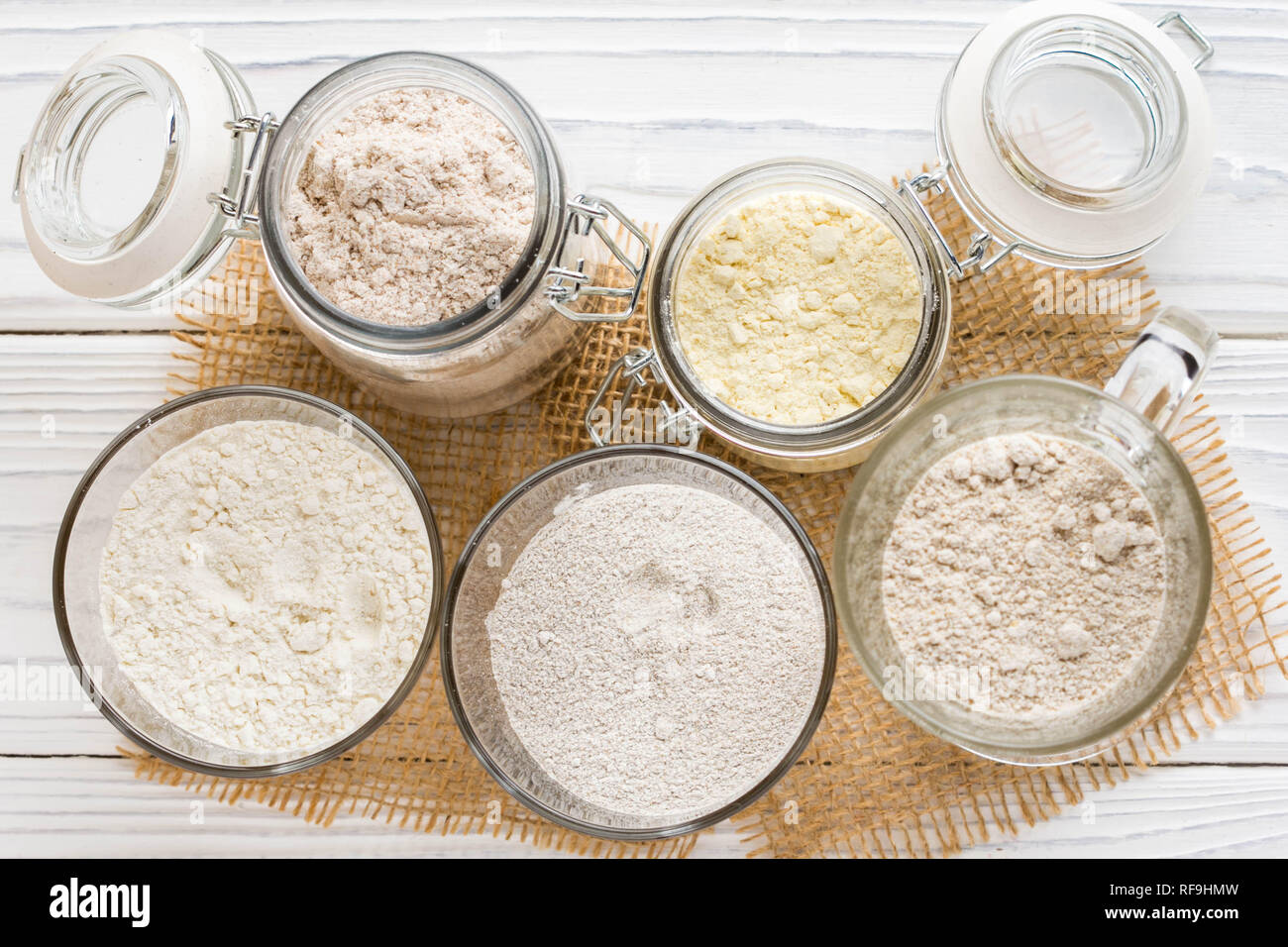 Different flour in glass jars, wheat, corn, rye, oats, spelt, flax
