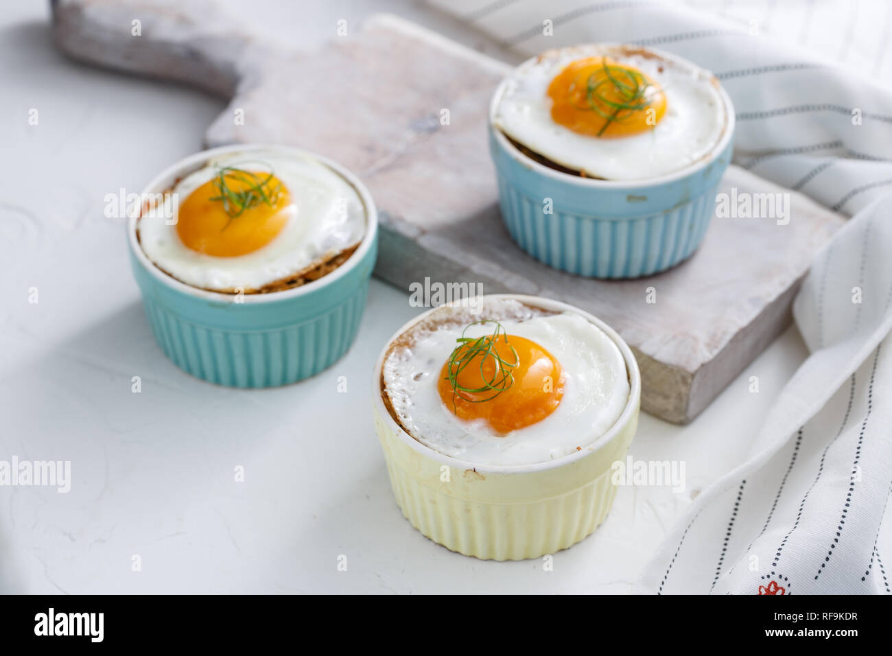 Three baked egg in ramekins on white background Stock Photo Alamy