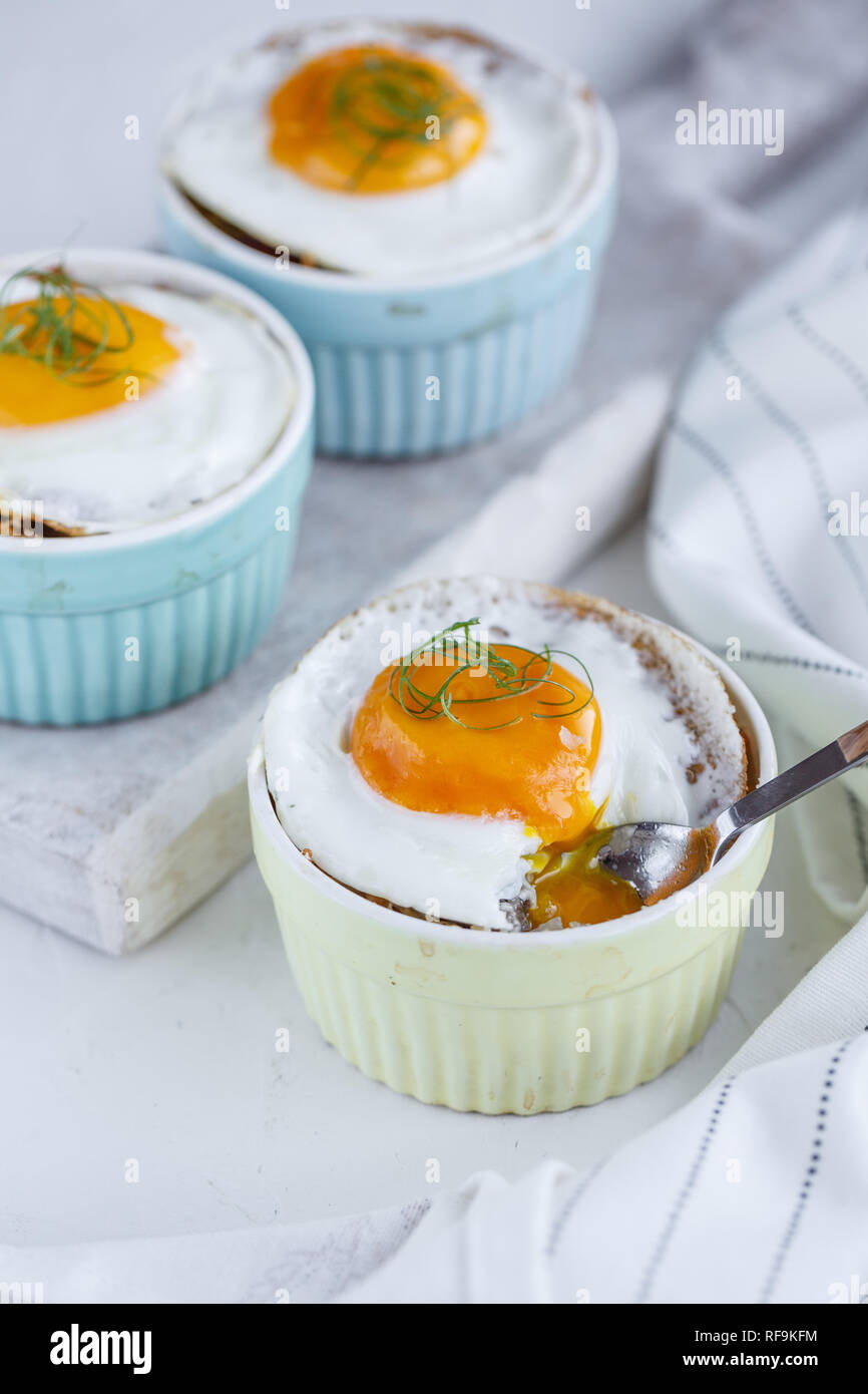 Three baked egg in ramekins on white background Stock Photo Alamy