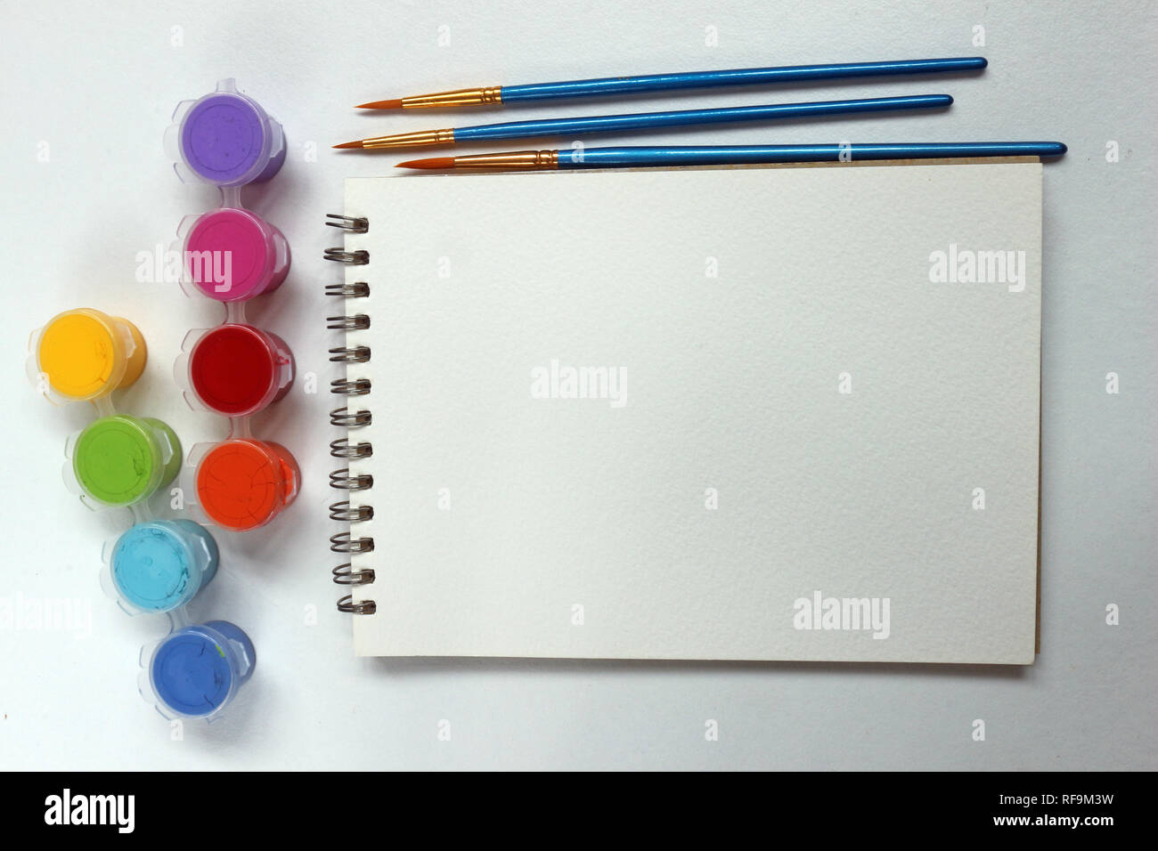 Blank spiral notebook with paint pots and paint brushes Stock Photo