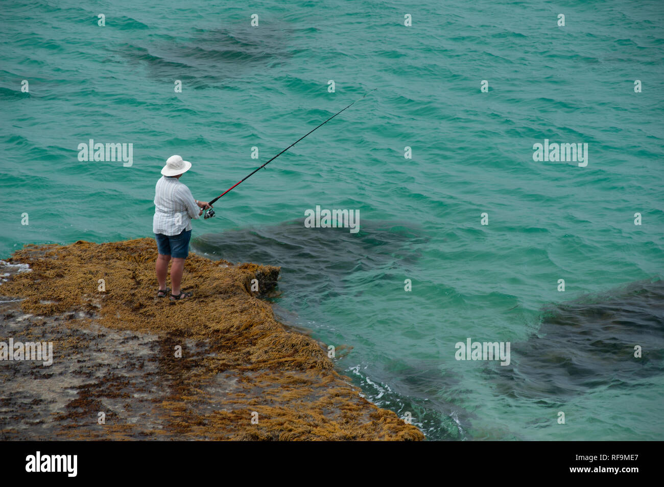 Man fishing off rocks at Vivonne Bay Jetty, Kangaroo Island, South
