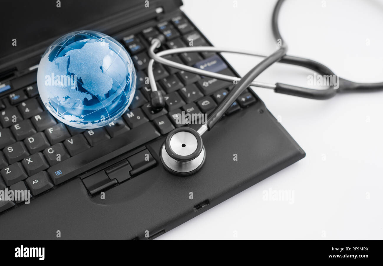 Glass globe and stethoscope on a computer keyboard Stock Photo - Alamy