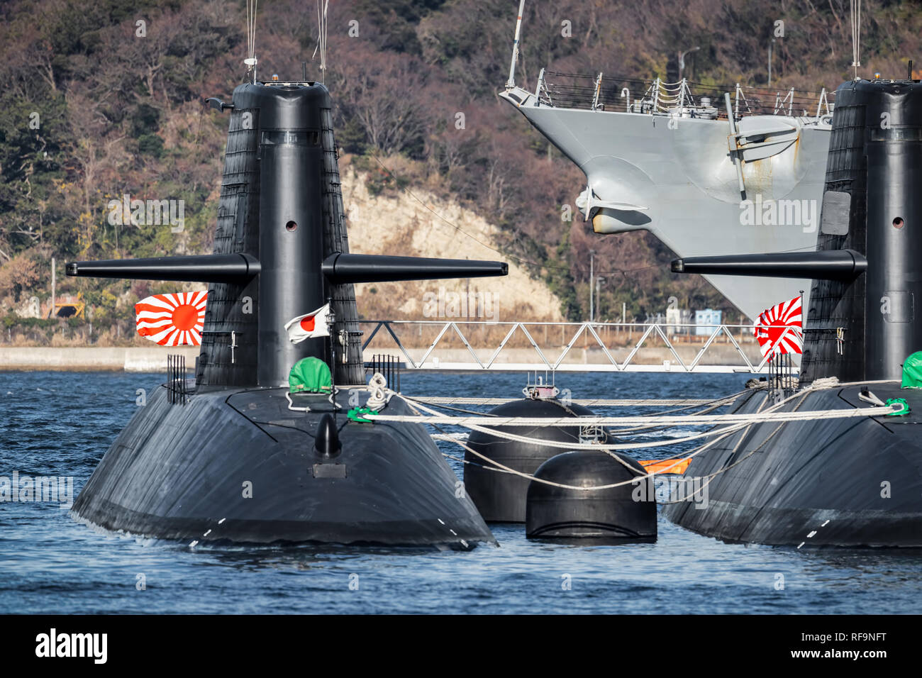 Two Japanese submarines flying their flags and moored at a dock in eastern Japan. Stock Photo