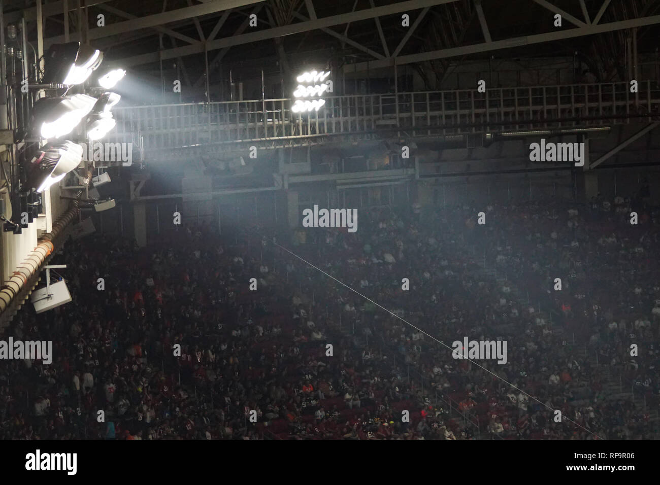 A group of stadium light illuminate a football field. Stock Photo