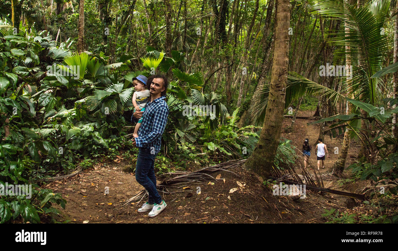 A photo of a man and his son walking in the tropical rain forest of the beautiful Manzanillo National Park, Costa Rica. Stock Photo