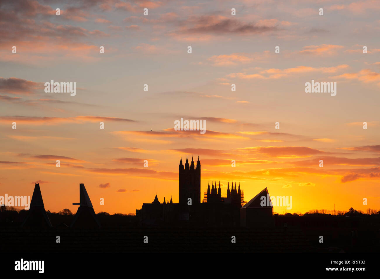 Vivid orange sunrise over Canterbury Cathedral and the Marlowe Theatre, December 12th 2018. Canterbury, Kent, UK. Stock Photo