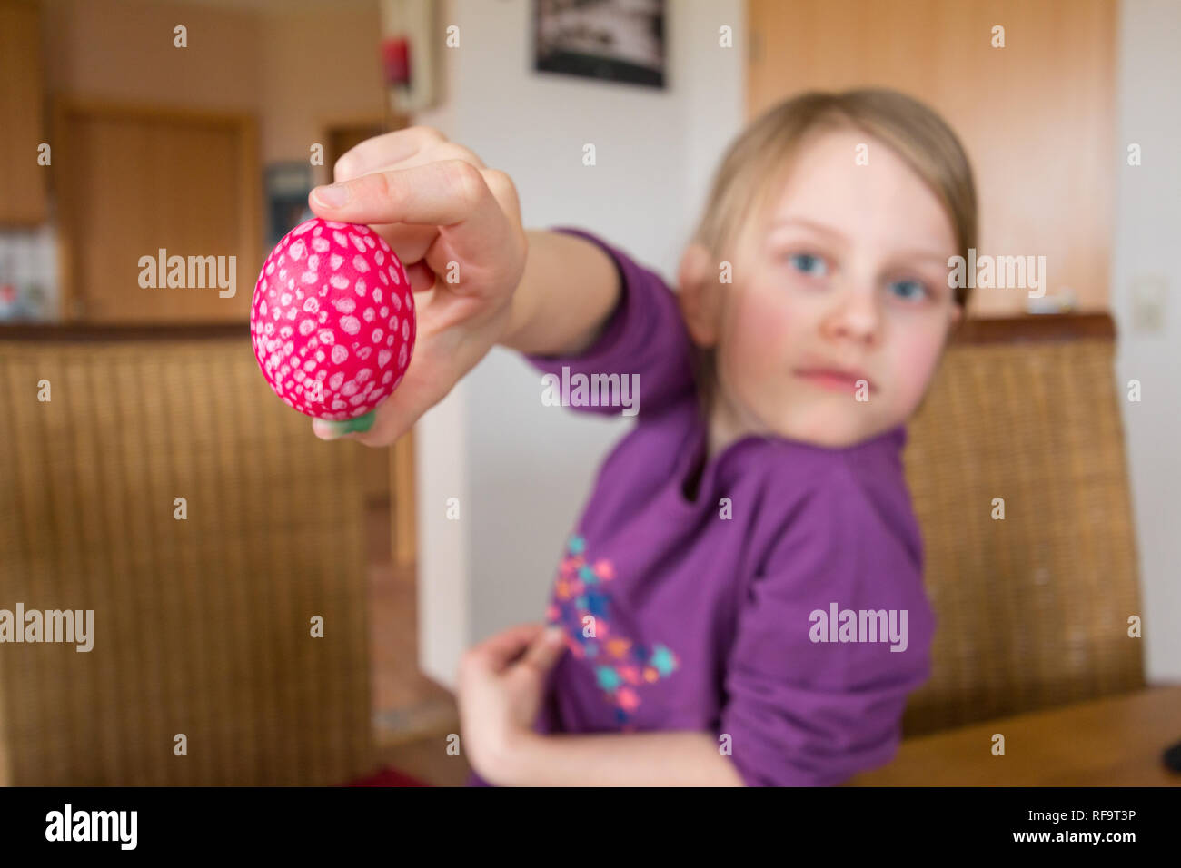A 7 Year Old Girl Smiles And Holds An Easter Egg Into The Camera Depth a-7-year-old-girl-smiles-and-holds-an-easter-egg-into-the-camera-depth