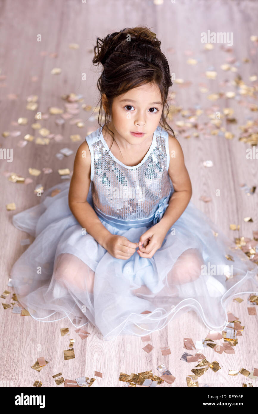 little girl in blue dress sitting on the floor with confetti Stock ...